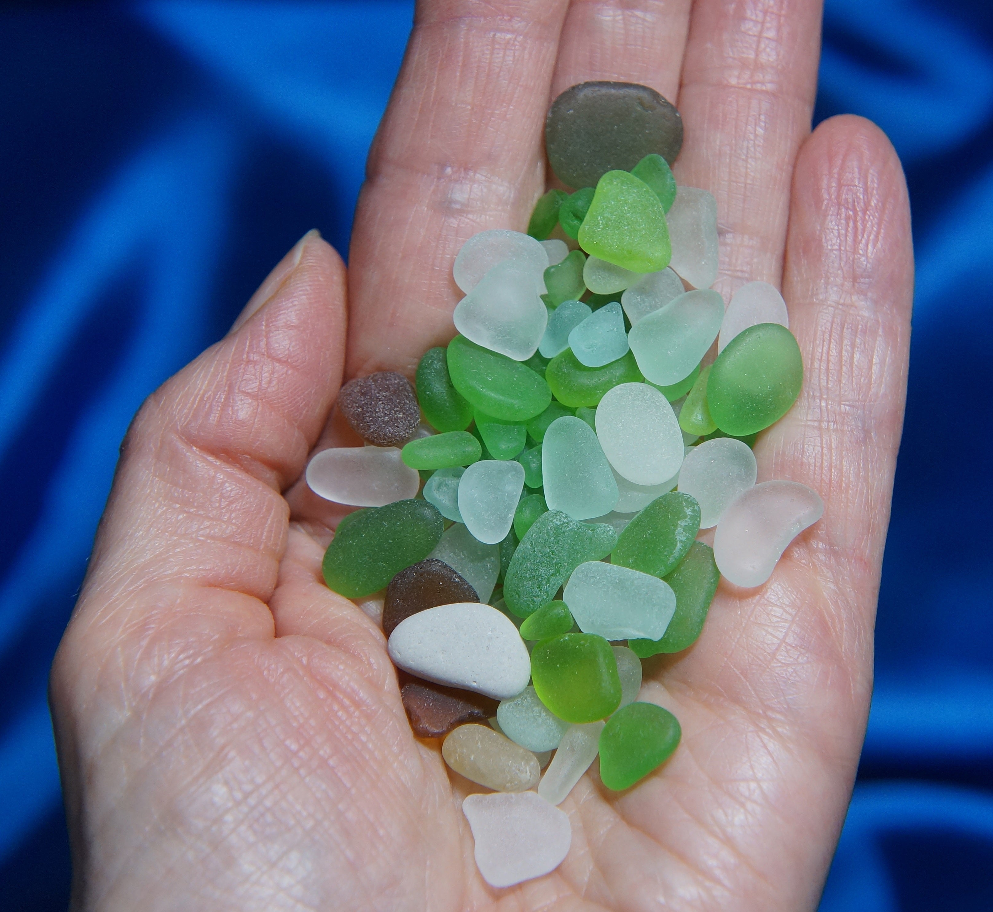 a handful of green, blue, and clear sea glass pieces